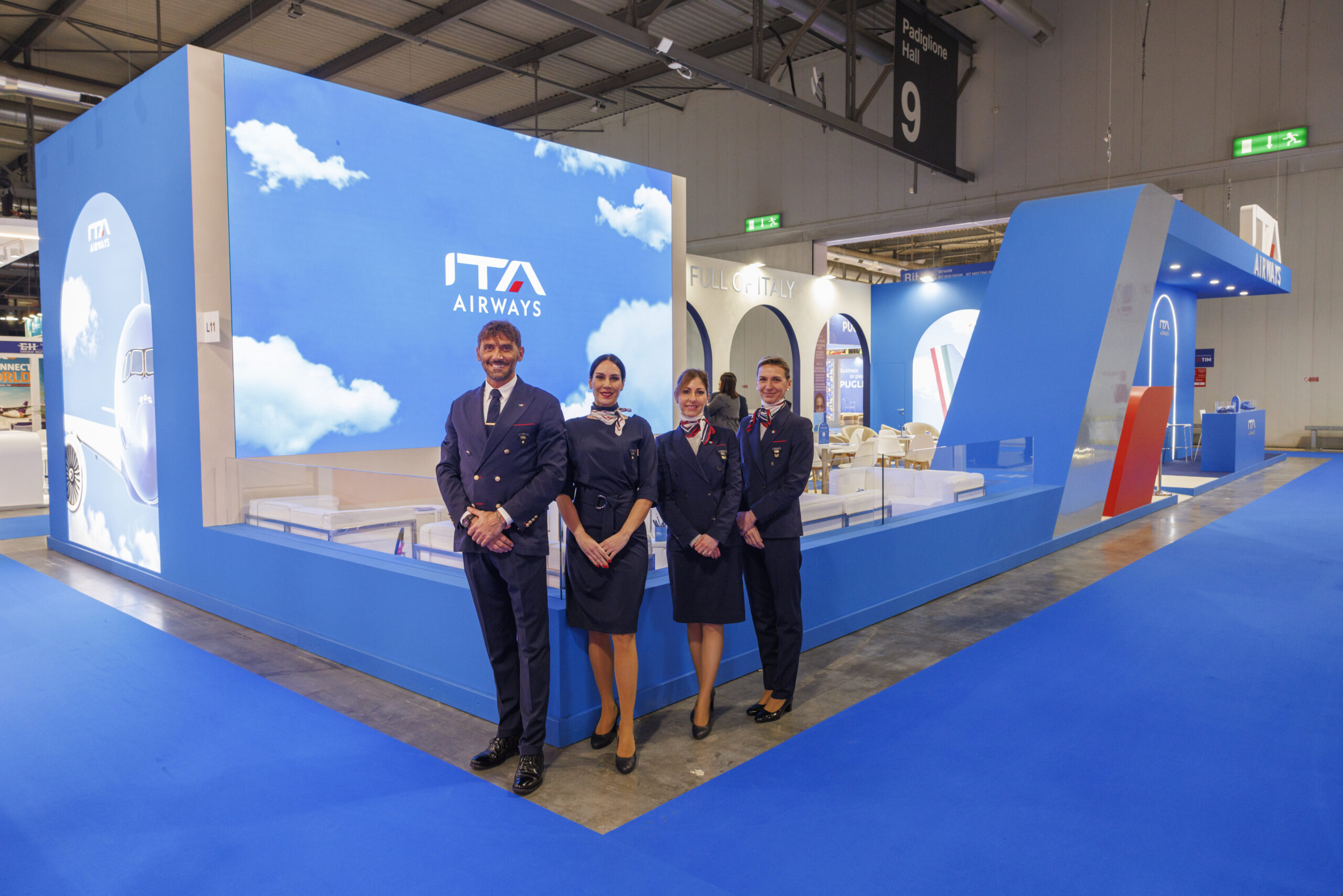 Stand di ITA Airways alla BIT 2025 nel Padiglione 9 di Fiera Milano Rho con il personale di bordo in divisa